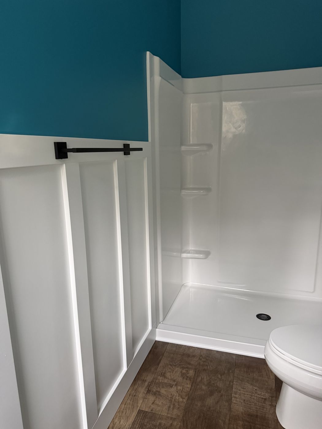 Bathroom with white board-and-batten wainscot and teal wall above