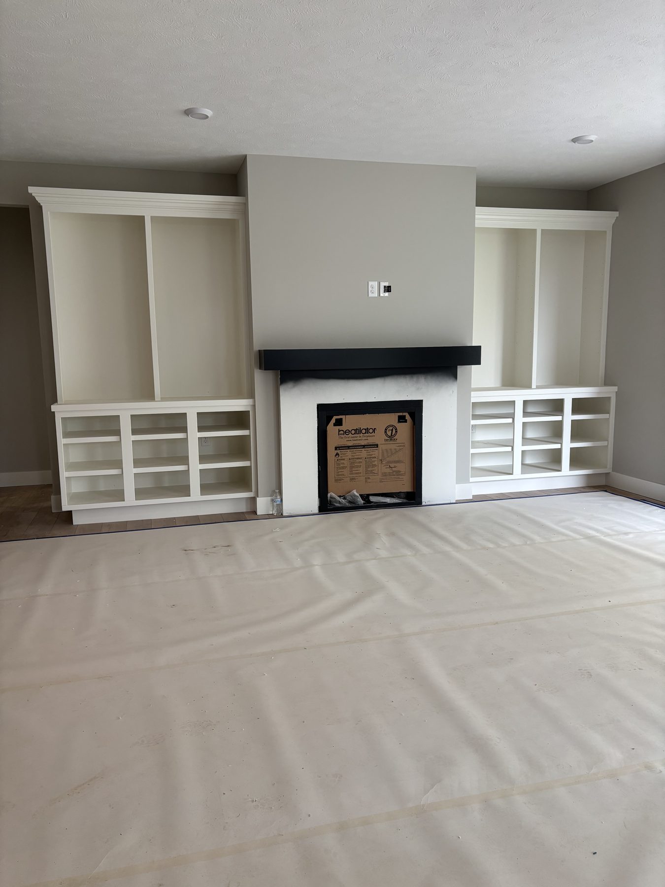 Fireplace surround with custom built-in shelving and base cabinets