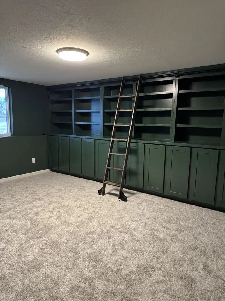 Green custom library wall with rolling ladder