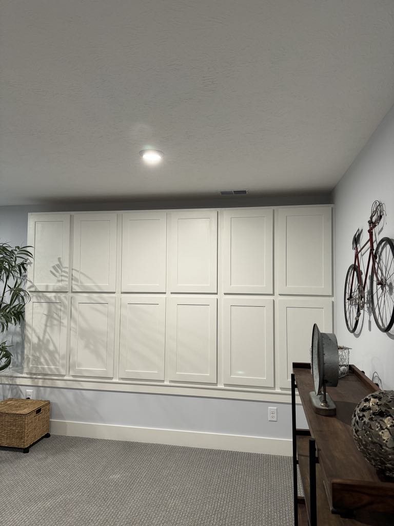 Wall-to-wall paneled storage cabinet built into a finished room